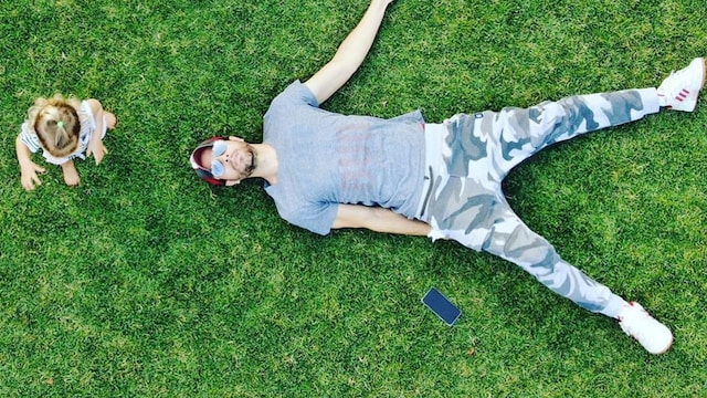 Enrique Iglesias lays on the grass while twins play