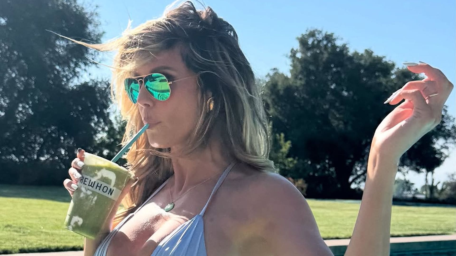 Heidi Klum sizzles in a blue bikini while sipping a kiwi smoothie