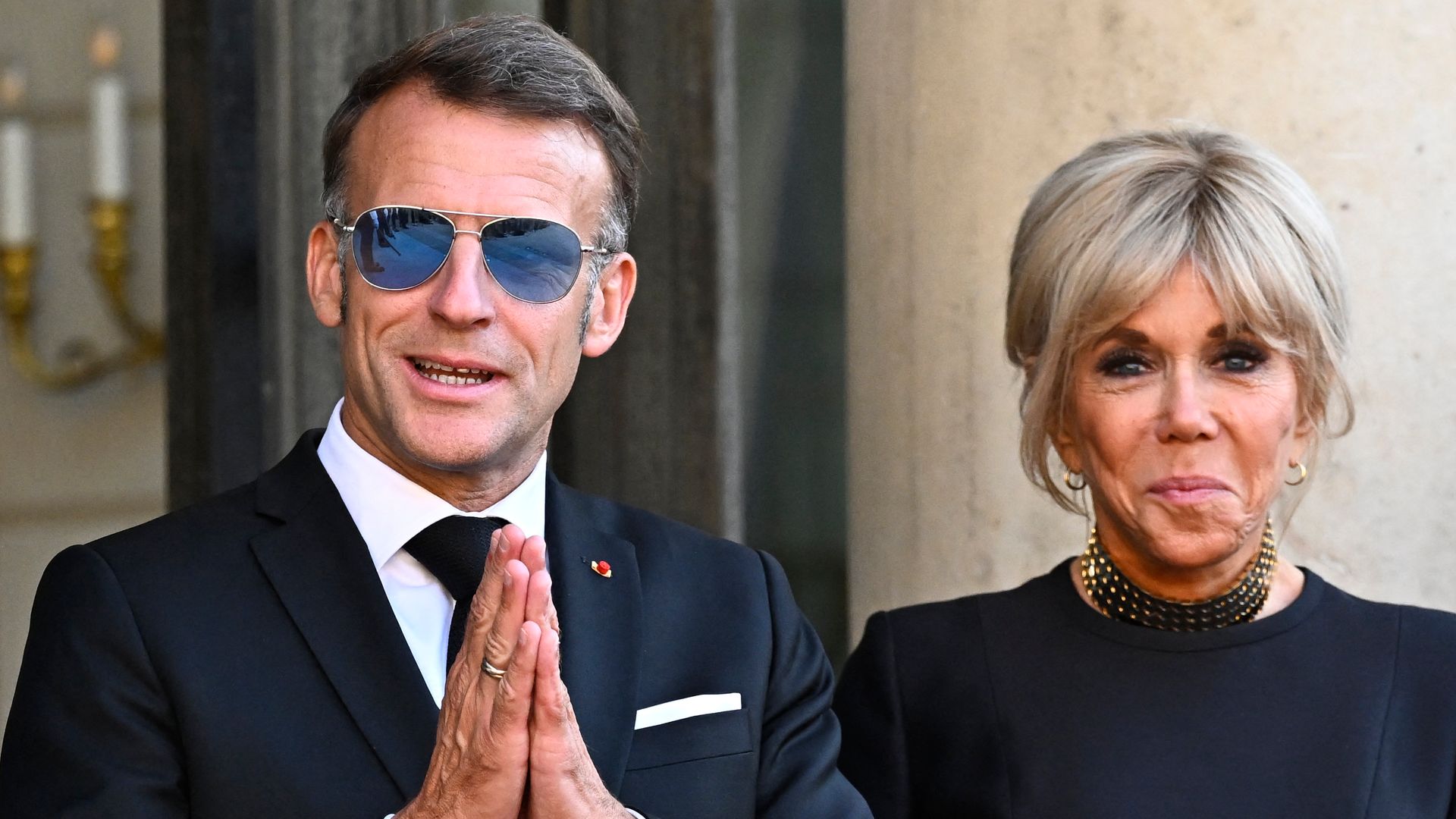 France's President Emmanuel Macron (L) getsures next to his wife Brigitte Macron at The Elysee Presidential Palace ahead of an official state dinner with South Africa's President and representatives in Paris on July 10, 2026. (Photo by JULIEN DE ROSA / AFP via Getty Images)