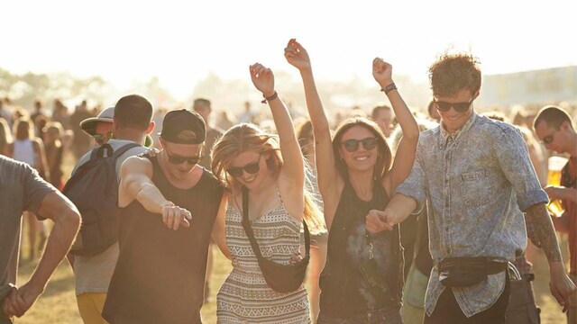 Young friends hanging out at big outside music festival