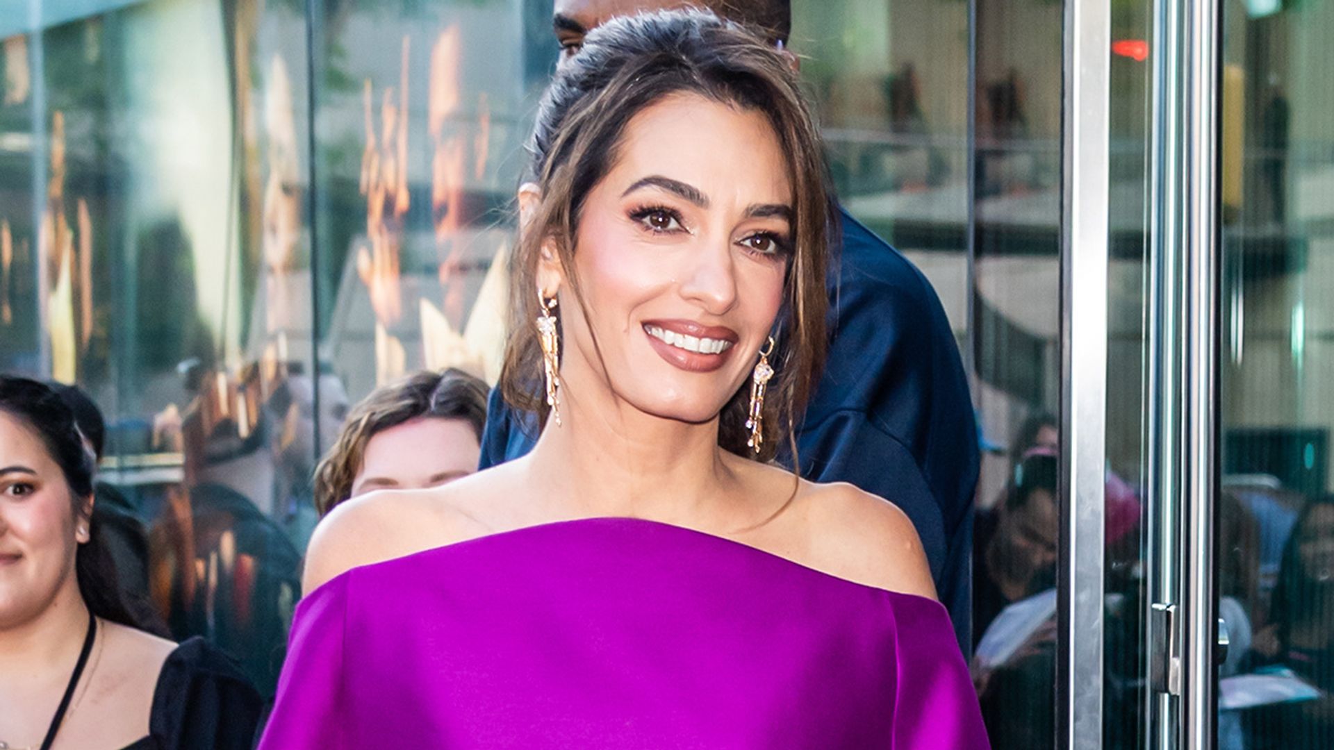 Amal Clooney puts a chic spin on the mini dress, showing off her legs in a bold purple look and gold pumps