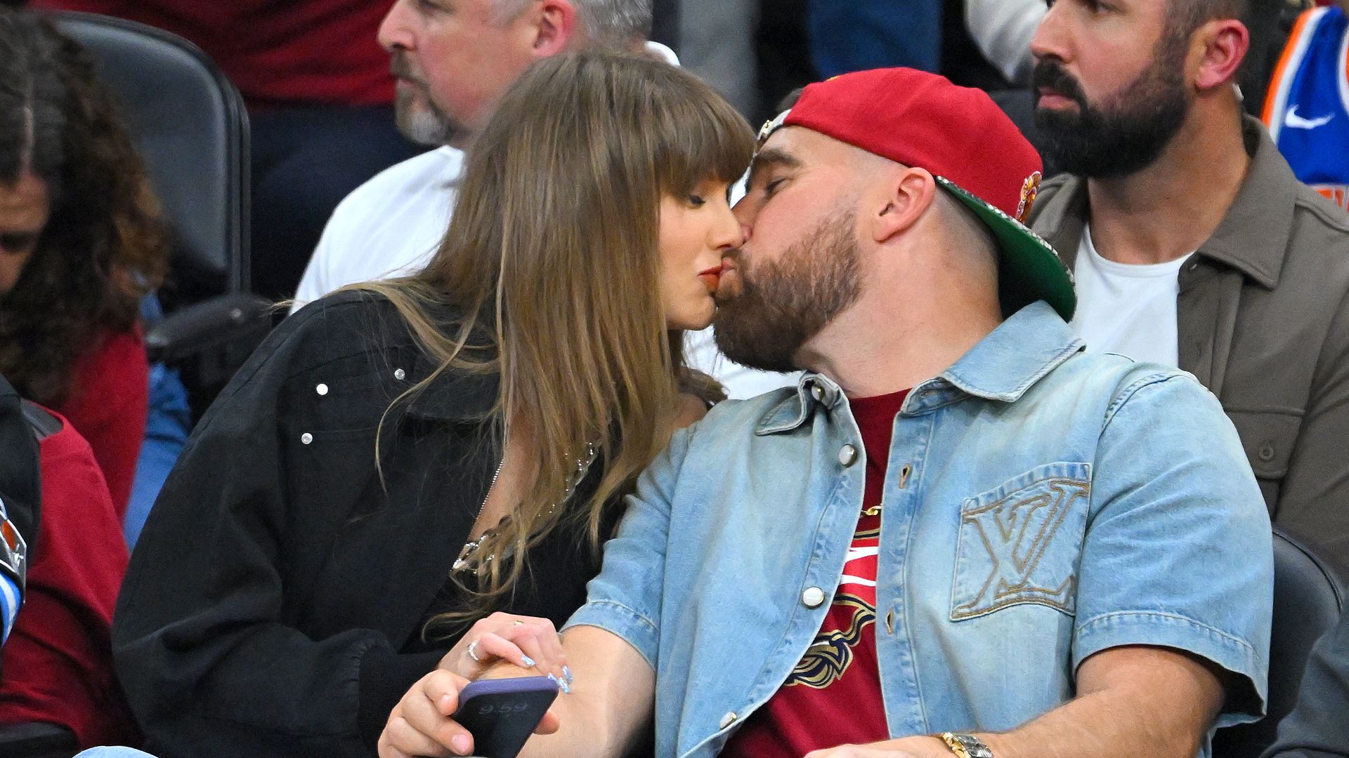 Singer Taylor Swift and Travis Kelce of the Kansas City Chiefs kiss during Game Three between the New York Knicks and the Cleveland Cavaliers in the NBA Eastern Conference Finals at Rocket Arena on May 23, 2026 in Cleveland, Ohio. NOTE TO USER: User expressly acknowledges and agrees that, by downloading and or using this photograph, User is consenting to the terms and conditions of the Getty Images License Agreement. (Photo by Jason Miller/Getty Images)