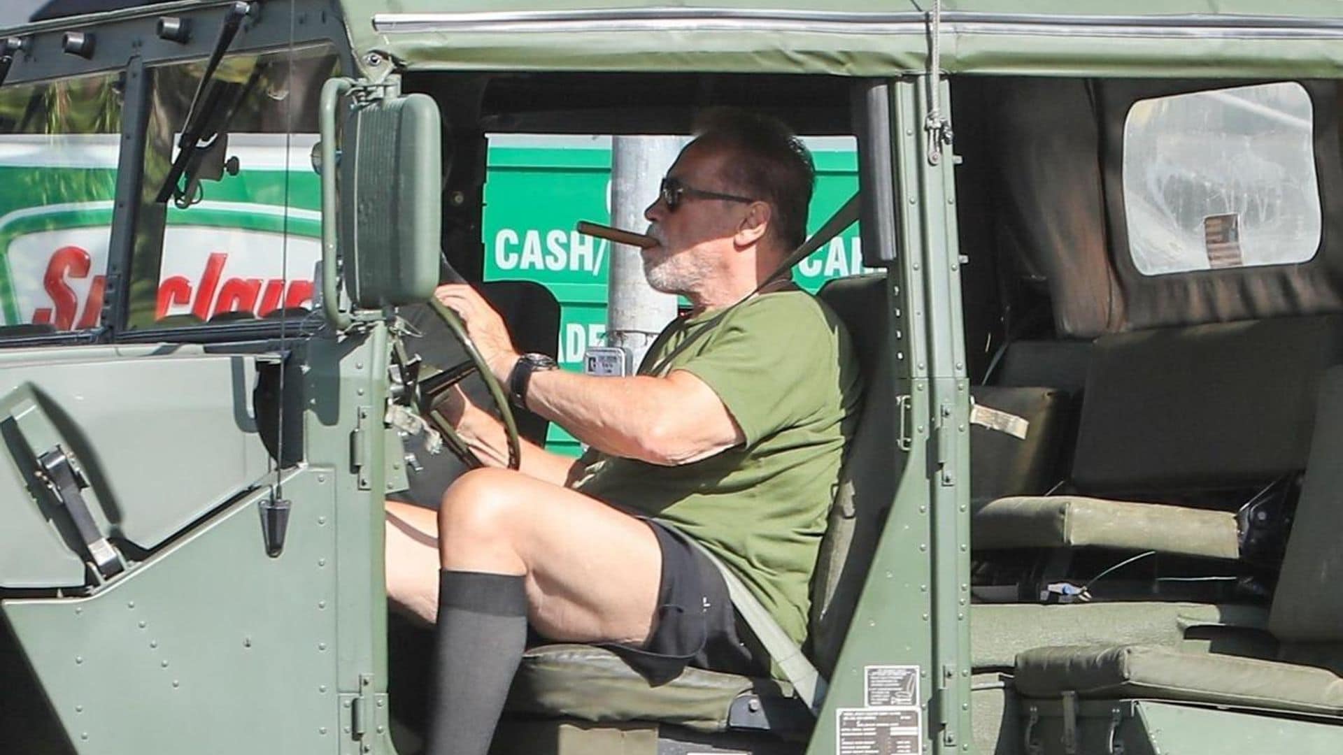 Arnold Schwarzenegger goes for a smoke and a drive on his huge Hummer