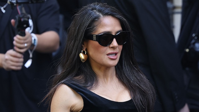 Salma Hayek poses in figure hugging velvet dress at Paris Fashion Week