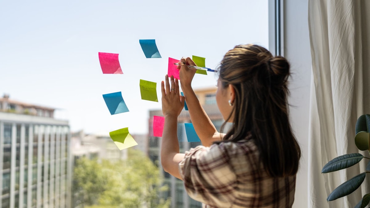 https://www.hola.com/us/horizon/landscape/e7430e41254c-a-woman-is-writing-on-a-window-with-colorful-sticky-notes.jpg?im=Resize=(1200)