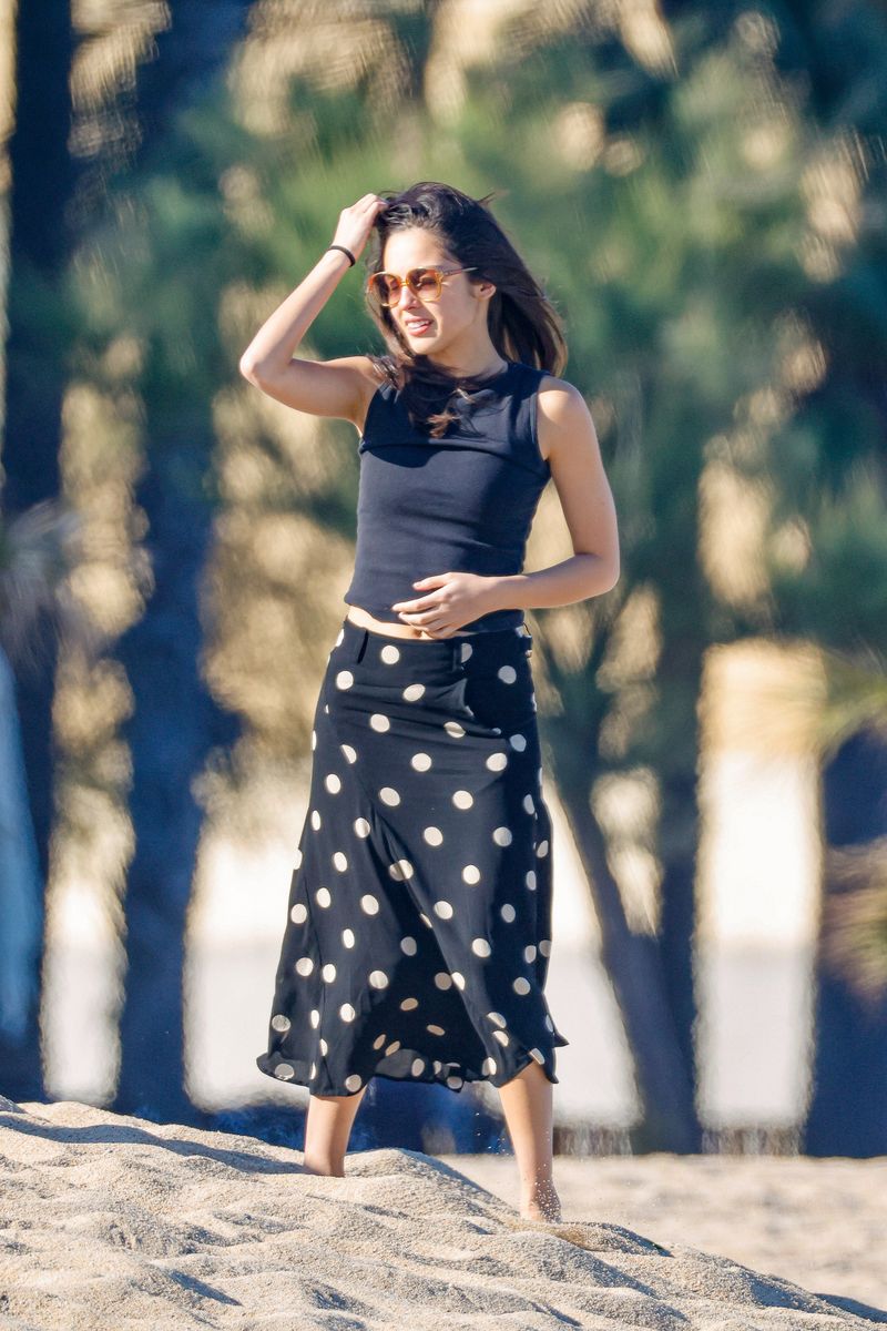 Olivia Rodrigo  looked chic yet understated in a fitted black sleeveless top paired with a breezy black midi skirt decorated with oversized white polka dots. 