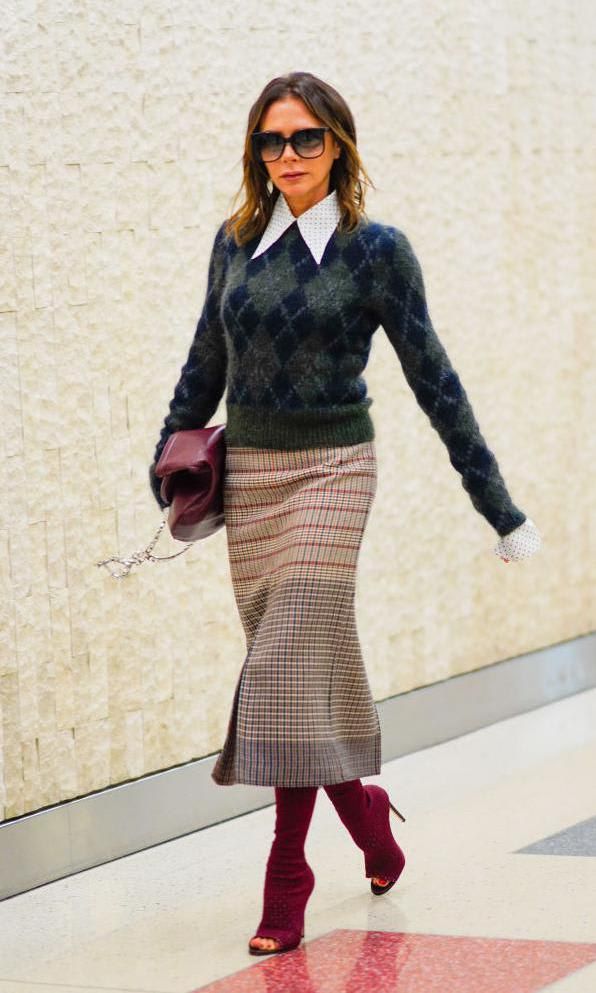 Victoria Beckham in a pointed-collar shirt, sweater and high boots