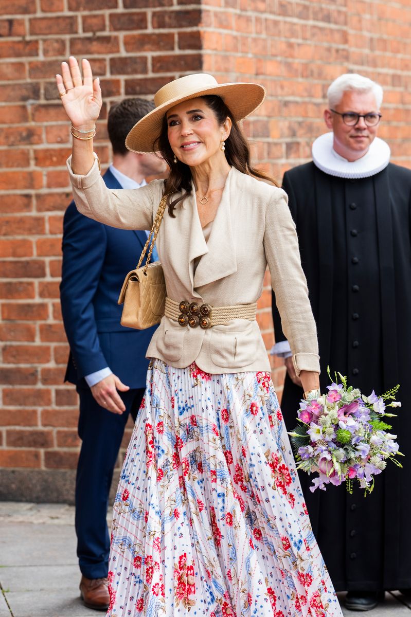 Queen Mary embraced summer elegance in a floral midi skirt, tailored blazer, and wide-brimmed hat as she arrived in Odense.