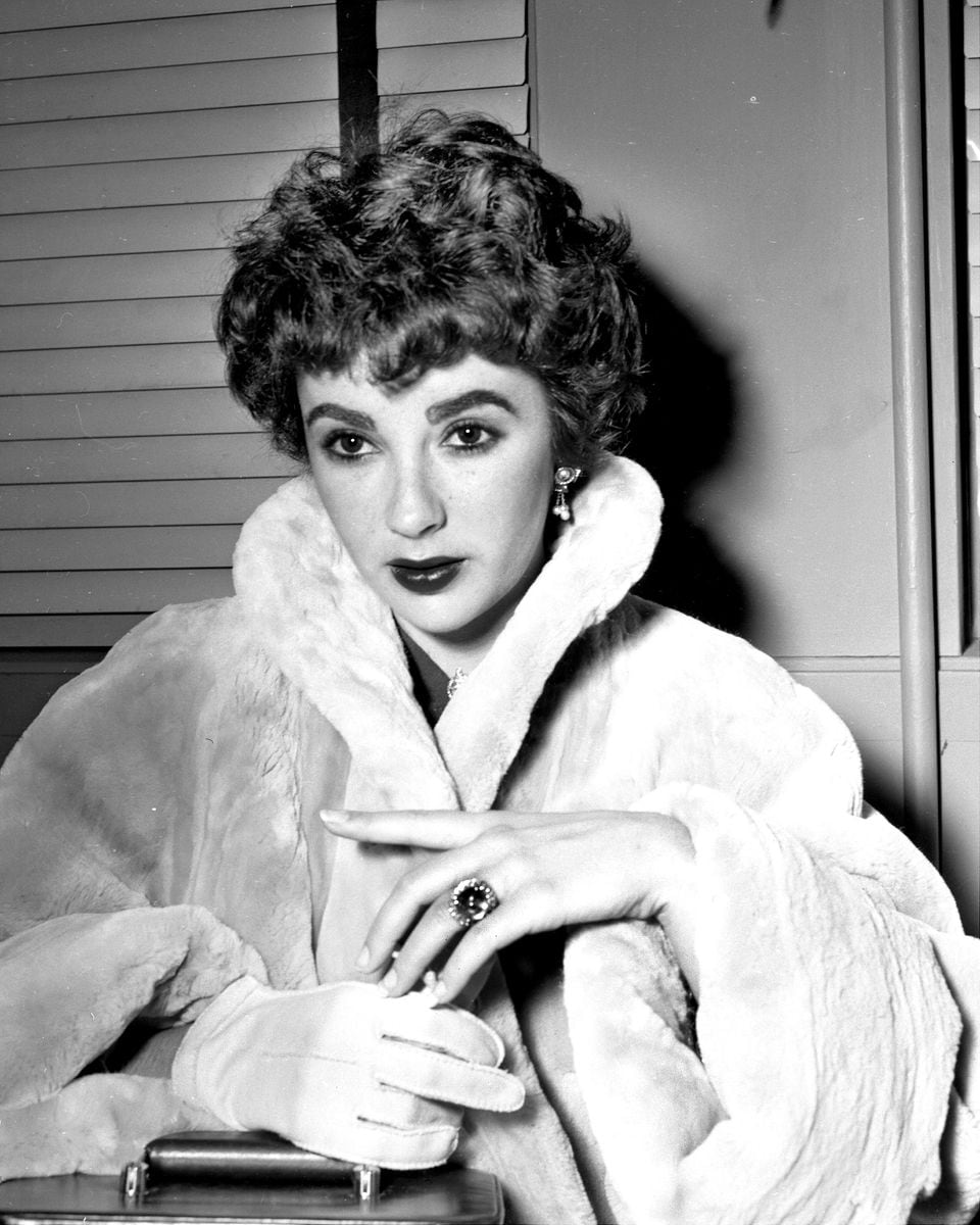 Elizabeth Taylor displays engagement ring at LaGuardia Field on her way to London, ahead of her wedding to Michael Wilding. 