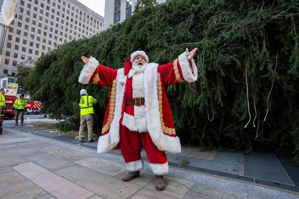Santa Claus arrives during the installation of the Rockefeller Center Christmas tree.