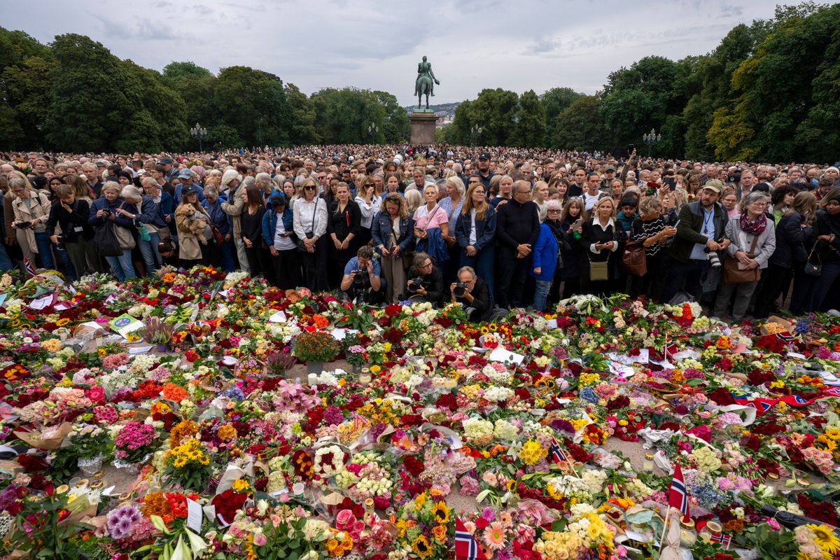 Mourners gather at a makeshift memorial of flowers to pay tribute to King Harald V of Norway who passed away, at the Royal Palace square in Oslo on August 28, 2026.