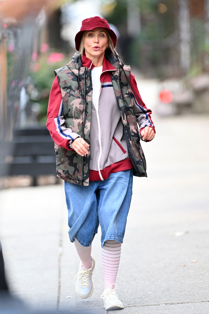 Cameron Diaz's outfit consisted of oversized denim shorts, a red track jacket layered beneath a camo puffer vest