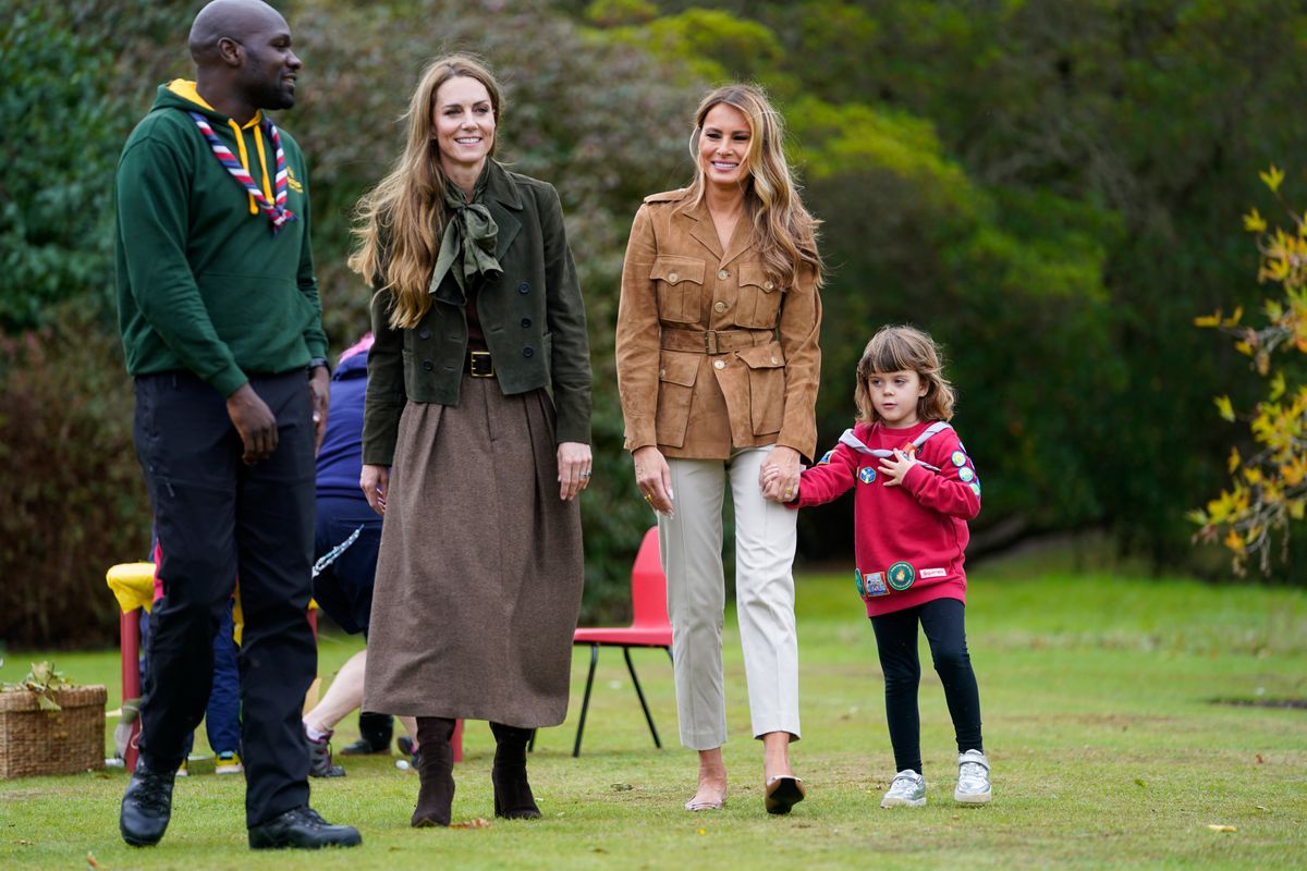 WINDSOR, ENGLAND - SEPTEMBER 18: U.S. First Lady Melania Trump (R) and Catherine, Princess of Wales walk with Chief Scout for the Scout Association Dwayne Fields as they meet members of the Scouts' Squirrels programme in the grounds of Frogmore Cottage, during the State visit by the President of the United States of America and U.S. First Lady Melania Trump, on September 18, 2025 in Windsor, England. (Photo by Nathan Howard - WPA Pool/Getty Images)