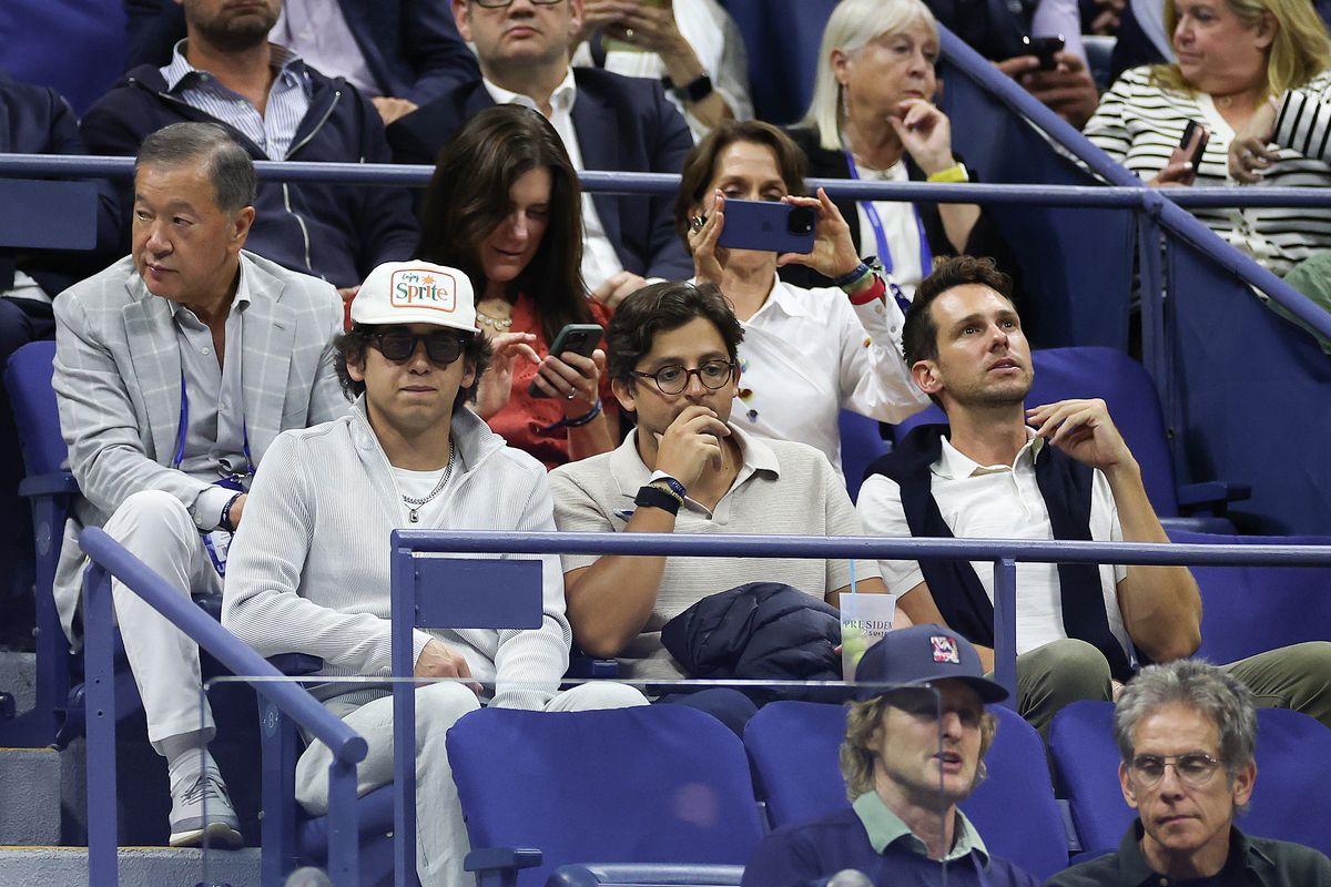 Marcello Hernandez watches Novak Djokovic play, sitting behind Ben Stiller and Owen Wilson