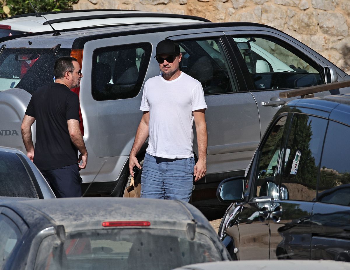 Leonardo DiCaprio sticks to his signature low-key style in a classic white tee, relaxed blue shorts, dark sunglasses and a baseball cap during his Ibiza getaway.