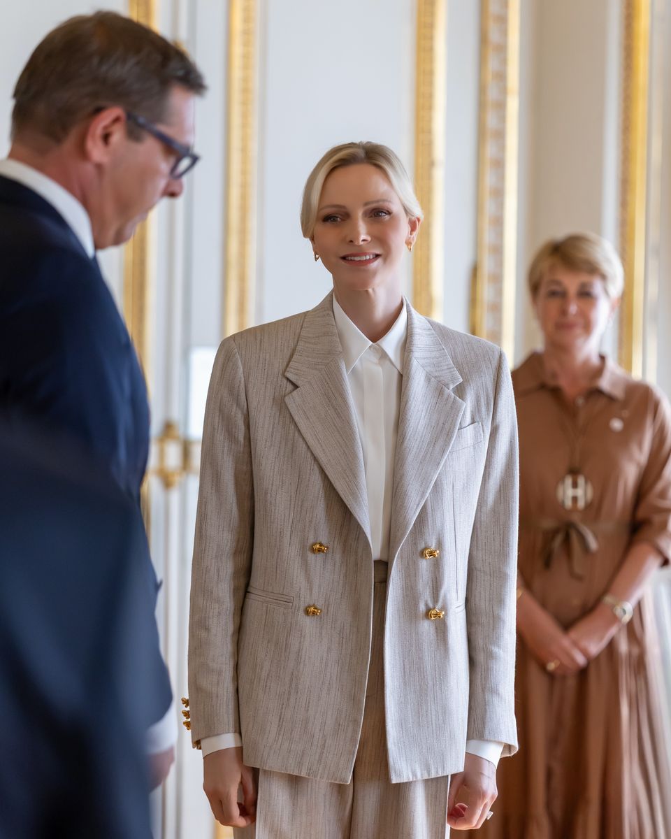 Princess Charlene of Monaco showcased sophisticated power dressing in a neutral double-breasted suit accented with gleaming gold buttons.