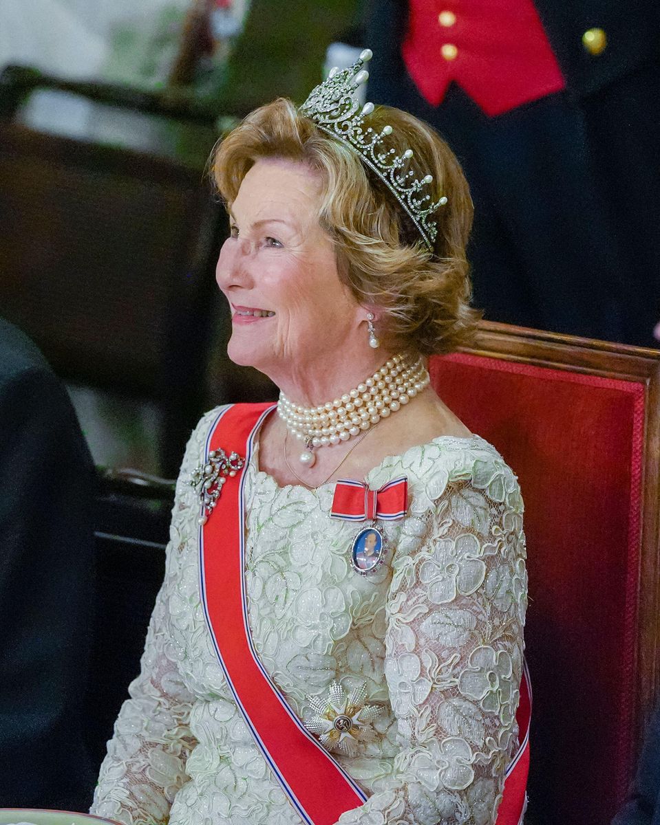 Queen Sonja wore an elegant ivory gown and pearl jewelry as she accompanied her son and granddaughter through the palace.