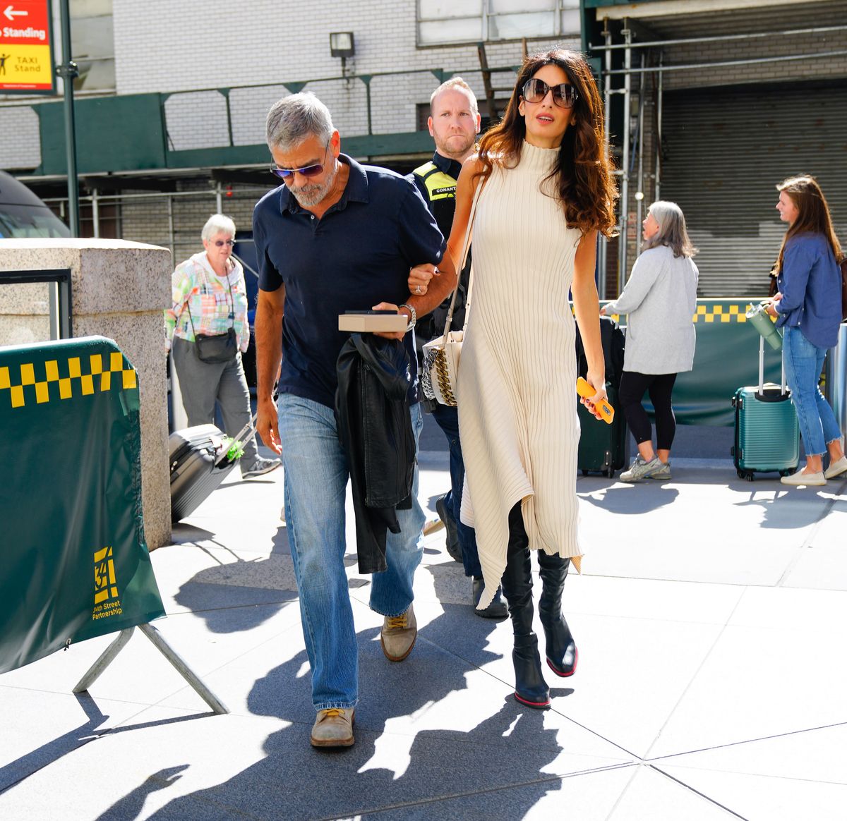 Amal Clooney mastered transitional dressing in New York City in September 2022, pairing a cream Stella McCartney knit midi dress with black knee-high boots and a coordinating shoulder bag. The sophisticated look offered an early glimpse at the human rights lawyer's go-to fall style.