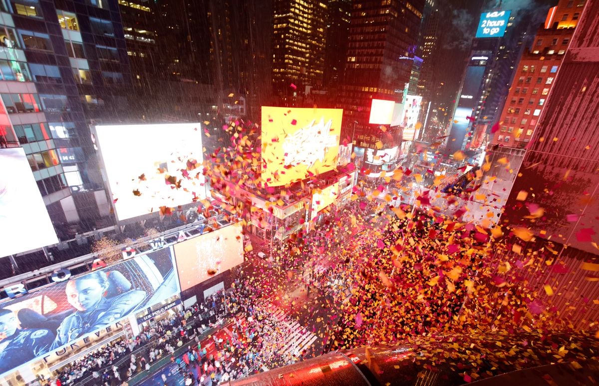 Confetti falls on revelers at 10 pm as they wait in the rain for the ball to drop during New Year's Eve festivities in Times Square.