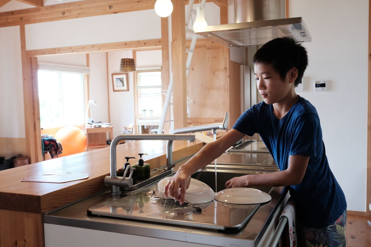 Boy washing dishes in kitchen