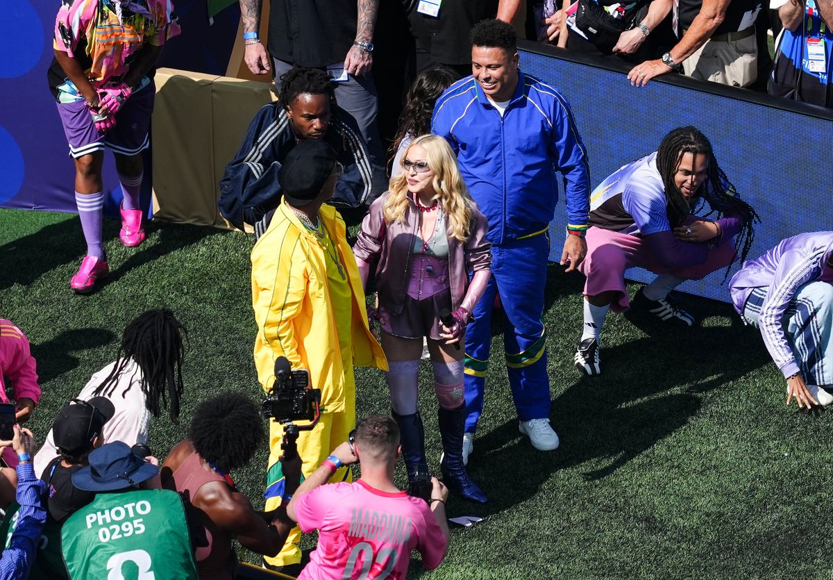 Madonna enters the stadium in a dune buggy driven by Brazilian soccer legends Ronaldo Nazário and Ronaldinho.