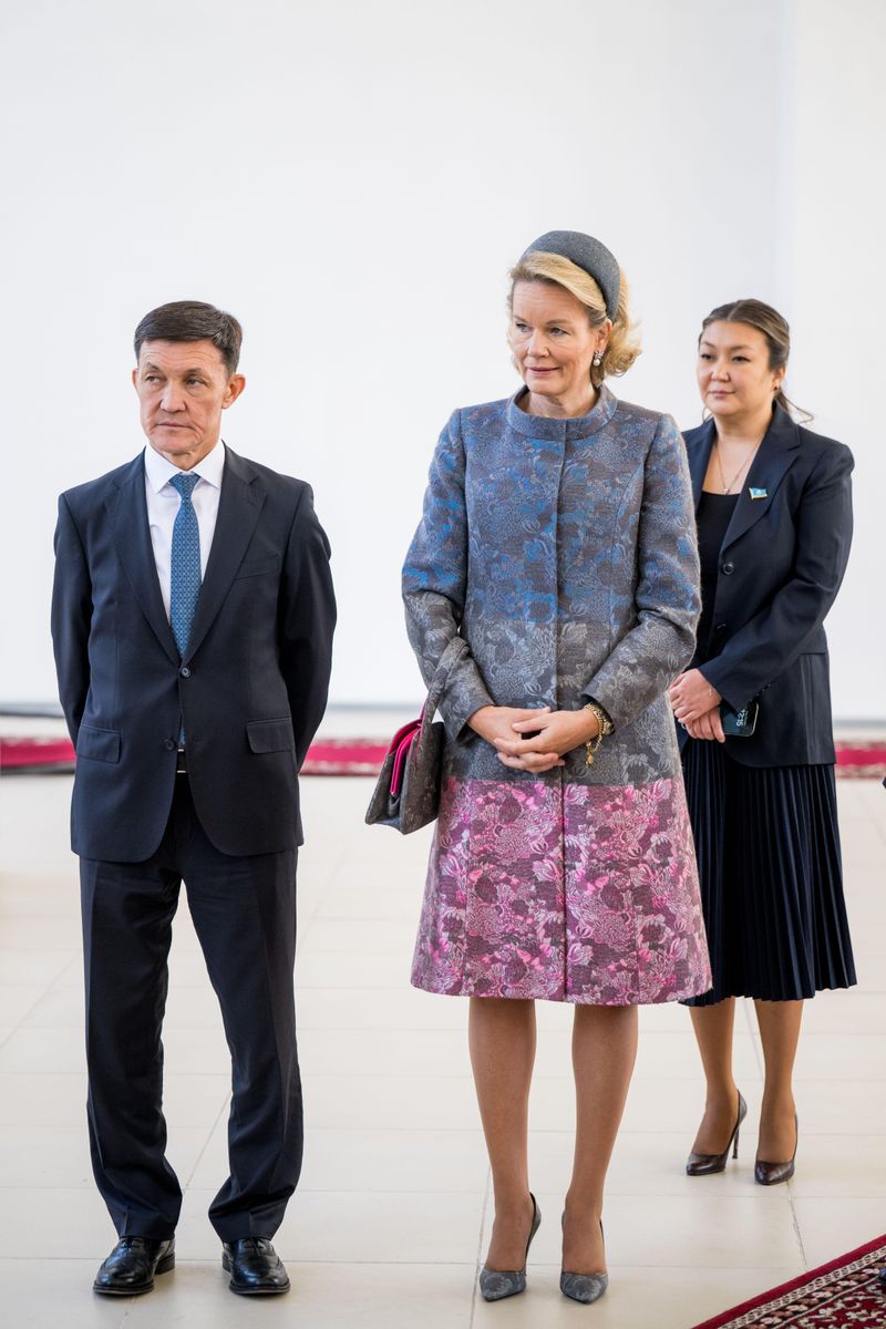 The queen’s structured coat combined blue and silver floral detailing with a vibrant pink panel around the hem.