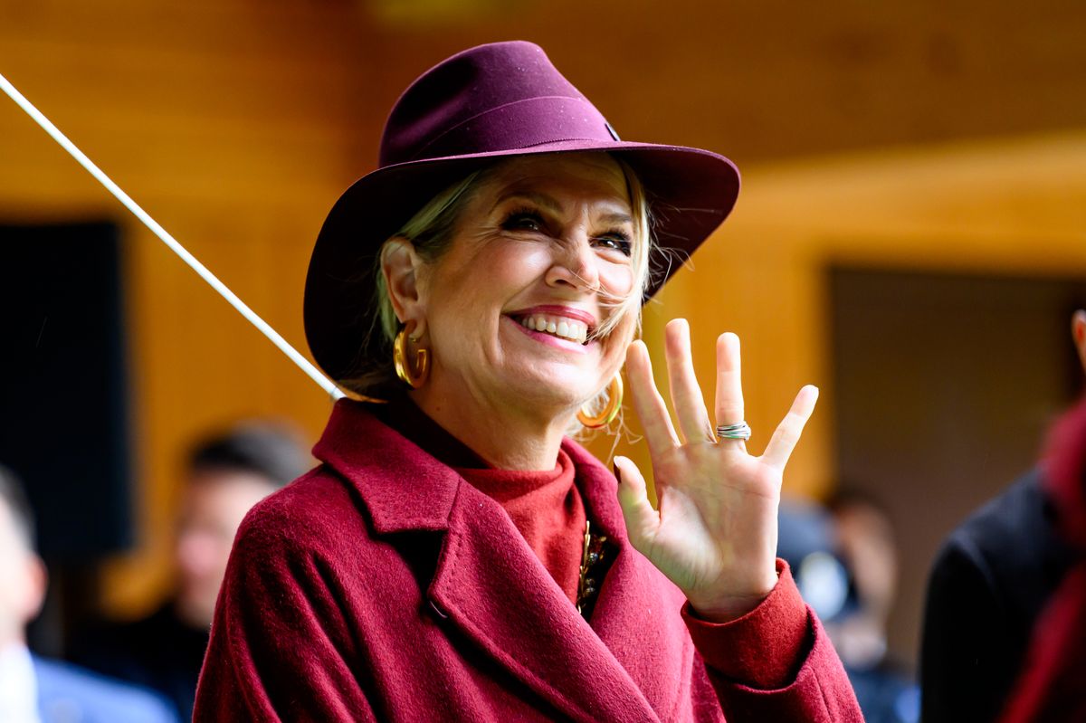 Queen Maxima's striking gold hoop earrings and burgundy-to-purple Maison Michel Henrietta hat completed the ensemble