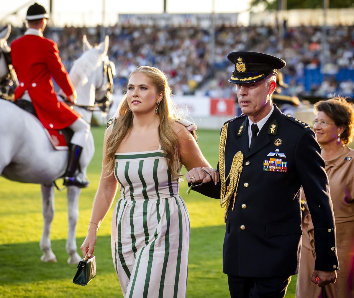 Princess Amalia looks effortlessly chic in a white and emerald green striped dress as she attends the prestigious equestrian event.