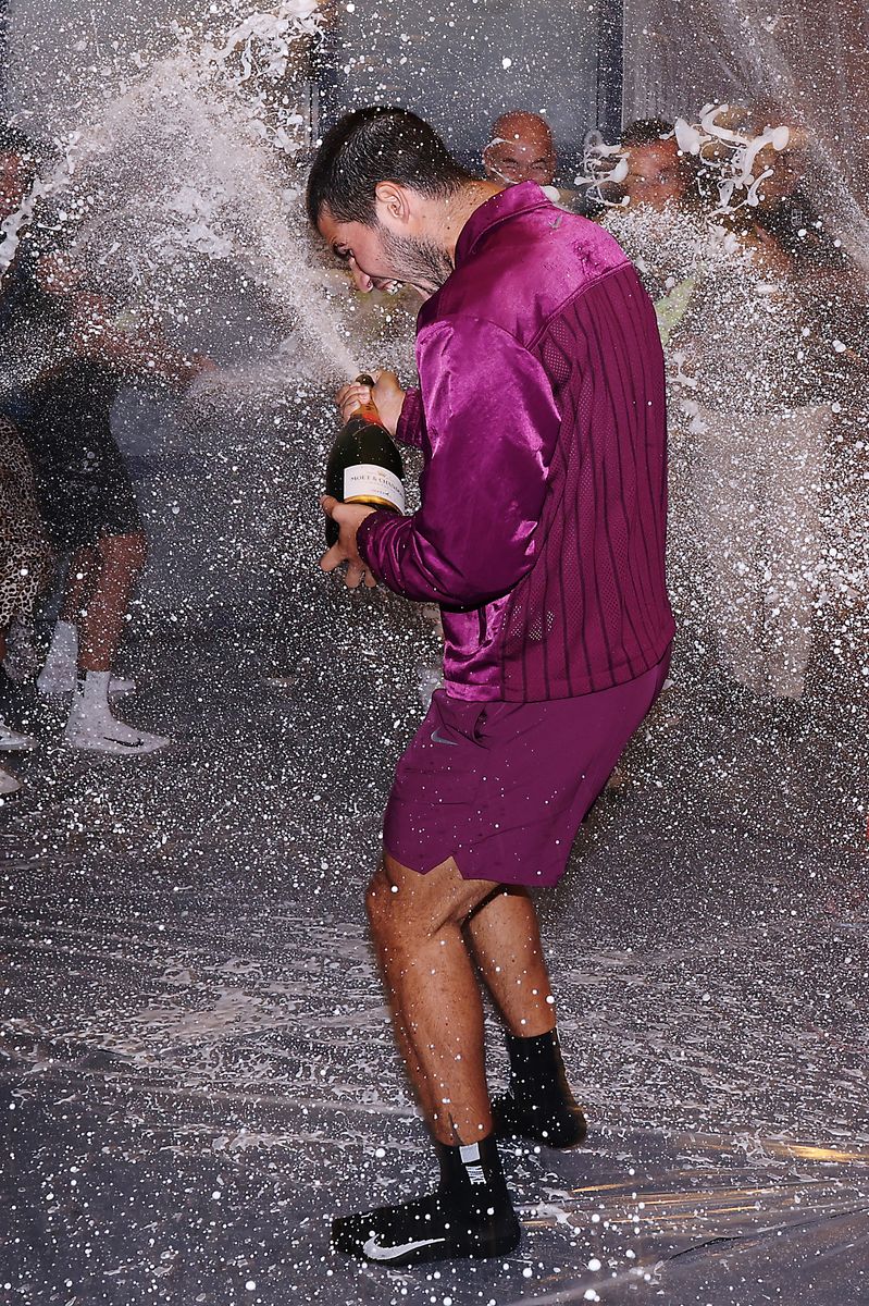 Carlos Alcaraz soaked in champagne while celebrating with his team in the locker room after defeating Jannik Sinner to win the 2025 US Open men’s singles final in New York.
