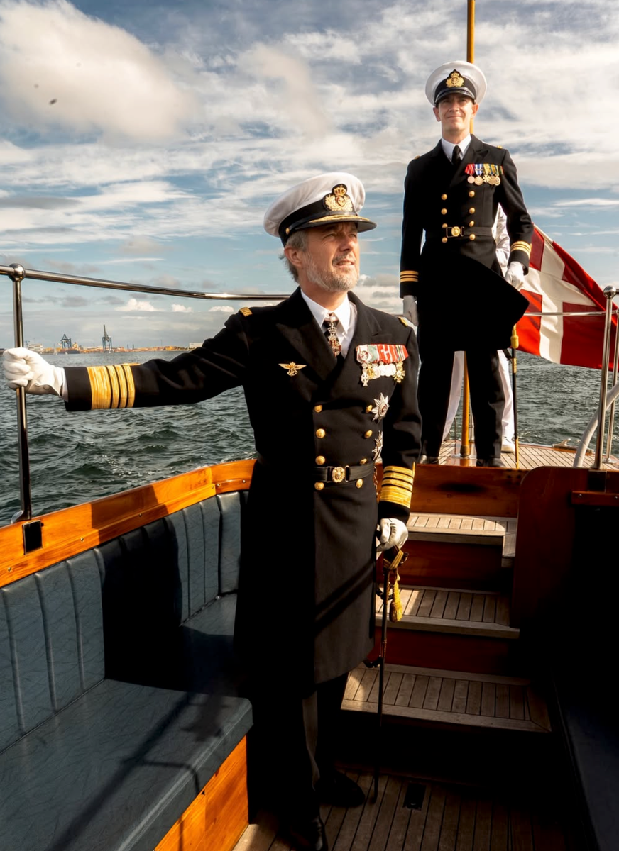 The Danish monarch looked commanding in his naval uniform as he greeted officers aboard the historic royal yacht.