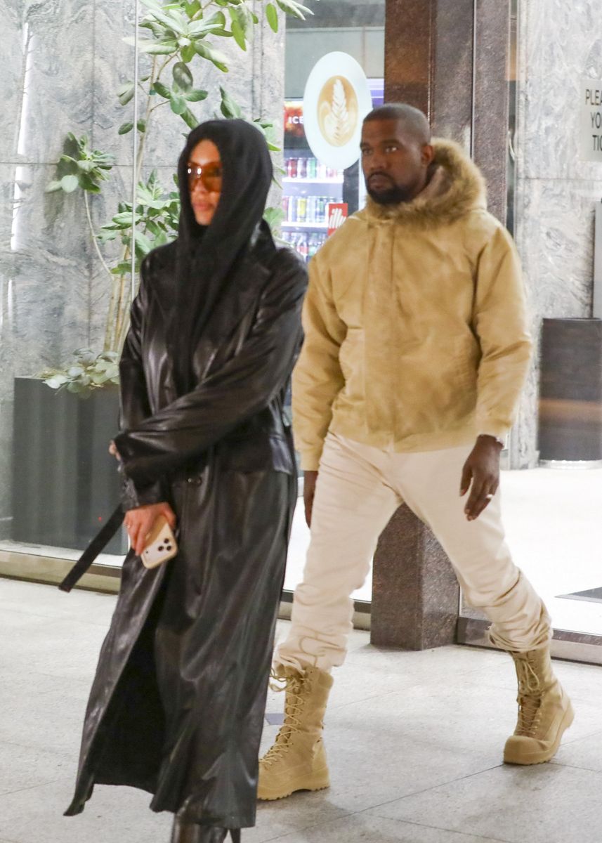 Photo 2026 Backgrid/The Grosby Group
EXCLUSIVE
Los Angeles, CA, October 5, 2026. Ye and Bianca Censori leave a movie theater in Westwood after a low-key date night together, one day after their appearance at ComplexCon. Despite temperatures in Los Angeles reaching around 100°F, both step out in heavy outerwear. Censori wears a floor-length glossy black leather trench coat with structured shoulders, wide lapels, long sleeves, and a belted construction over a black hooded top and fitted black leggings. She completes the look with dark brown knee-high stiletto boots and oversized amber-tinted rectangular sunglasses. Ye wears a beige hooded bomber jacket with a fur-trimmed hood, zip-front construction, ribbed hem and cuffs, and a relaxed fit, paired with off-white trousers and tan lace-up combat boots with thick soles.***Ye y Bianca Censori salen de un cine en Westwood después de una cita nocturna discreta, un día después de su aparición en ComplexCon. A pesar de que las temperaturas en Los Ángeles rondaron los 100 °F, ambos llevan prendas de abrigo pesadas. Censori viste un trench negro de cuero brillante hasta el suelo, con hombros estructurados, solapas anchas, mangas largas y cinturón, sobre un top negro con capucha y leggings negros ajustados. Completa el look con botas marrón oscuro hasta la rodilla de tacón aguja y gafas de sol rectangulares oversized con lentes ámbar. Ye lleva una bomber beige con capucha ribeteada en pelo, cierre frontal, puños y bajo acanalados y corte relajado, combinada con pantalones off-white y botas de combate marrón claro con cordones y suela gruesa.
Byline: BACKGRID /RMCL, BUFR, SPOT, NGRE / GROSBY GROUP