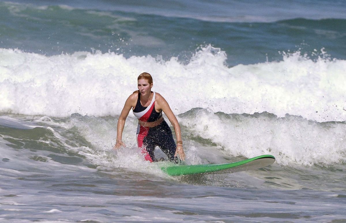 The mother of three wore a striking red, white and navy color-blocked surf set for the active outing.