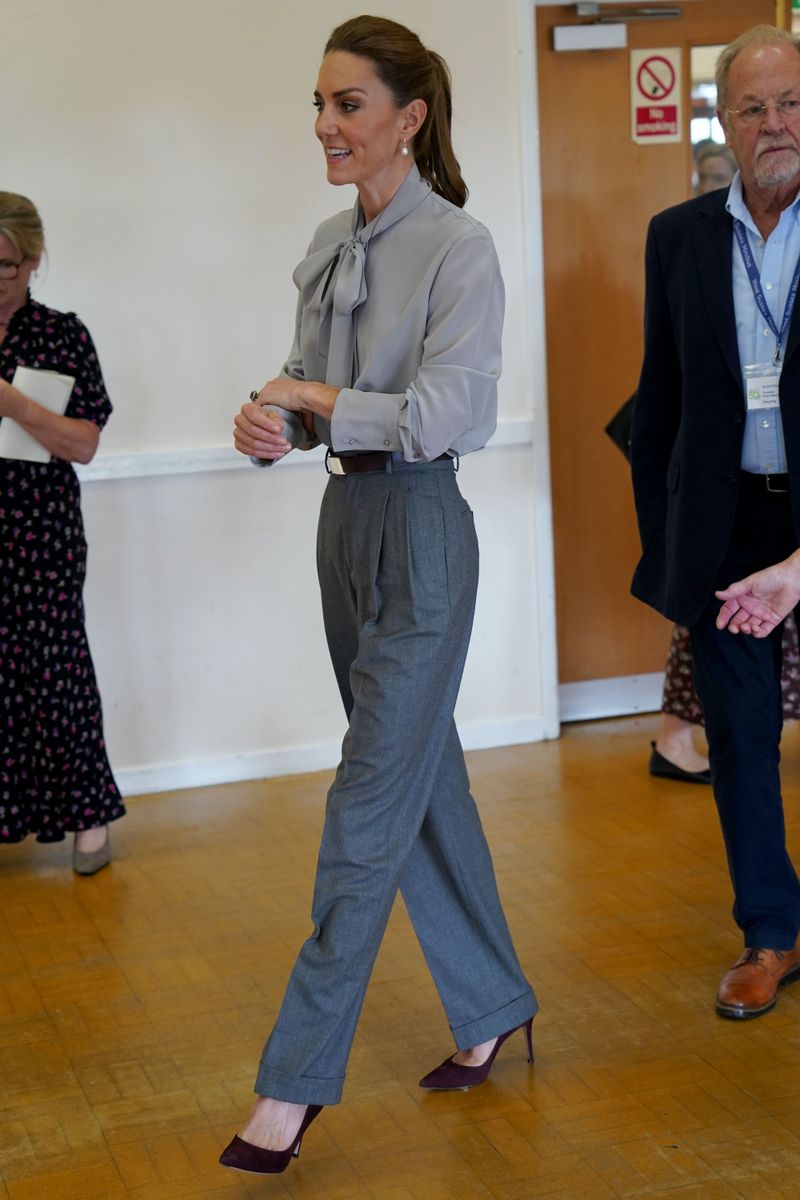 Kate's look started with a soft gray tie-neck blouse, worn with high-waisted gray tailored trousers.