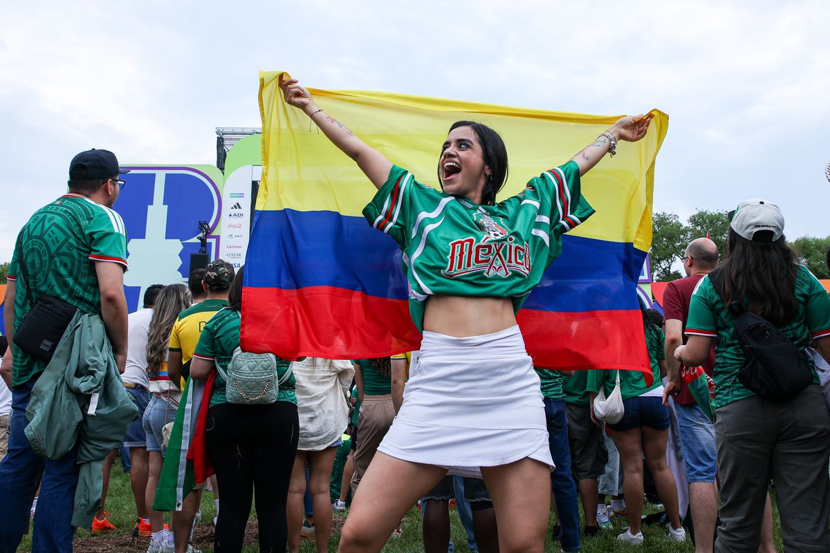 A female fan with a Colombia flag and Mexico jersey poses for a picture at the FIFA Fan Festival during the 2026 FIFA World Cup.