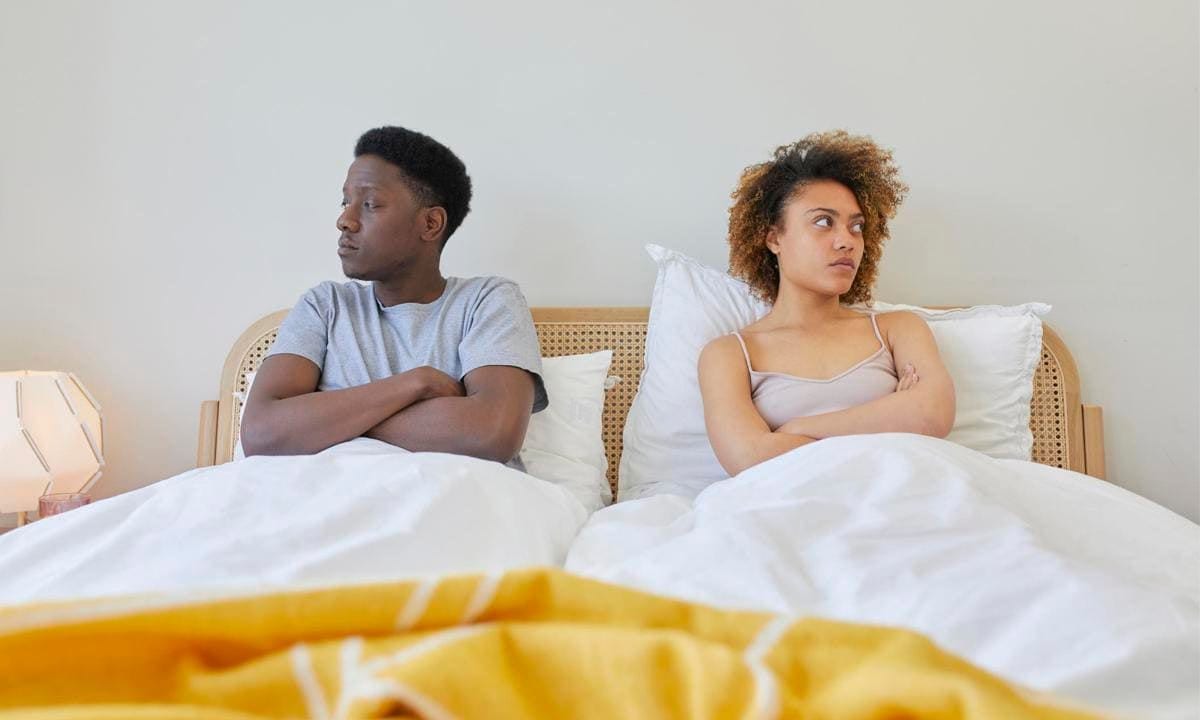 Young couple on bed, they are looking away