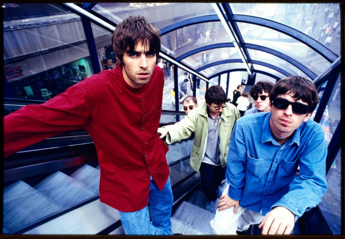 British rock band Oasis (Noel Gallagher, Liam Gallagher, Paul McGuigan, Paul Arthurs, Tony McCarroll) on Market St, Manchester, 2 August 1994