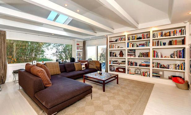 Jake's Hollywood home features a spacious living room with a wall of built-in bookshelves.