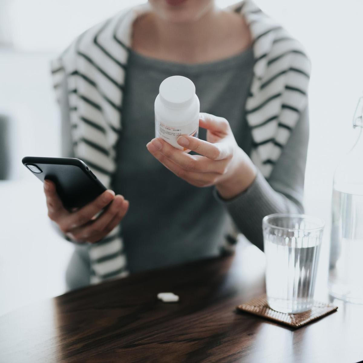 Close up of young Asian woman holding a pill bottle