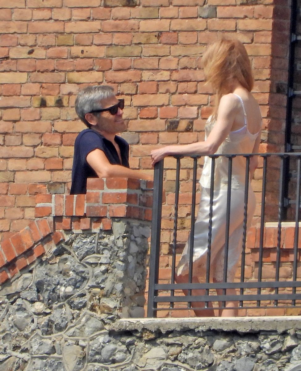 Reinstein leaned against the terrace wall while the two chatted from opposite sides of the balcony