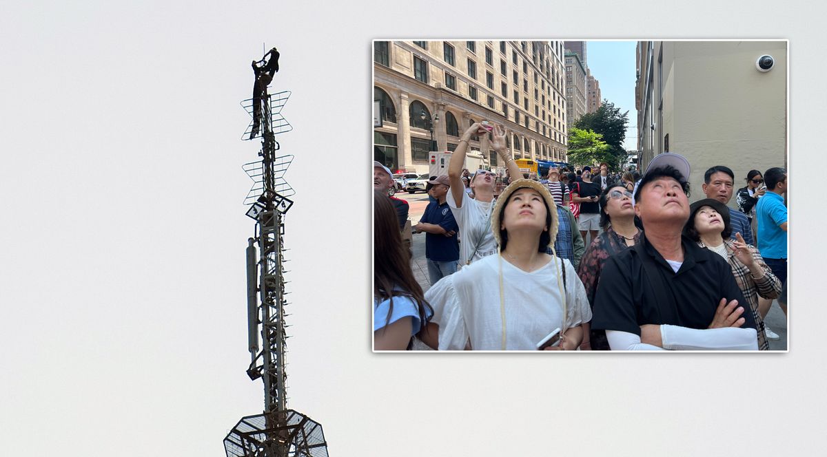 Two people are pictured on the top spire of the Empire State Building (main) as people watch from below (inset) on Wednesday, July 1, 2026, in New York City.