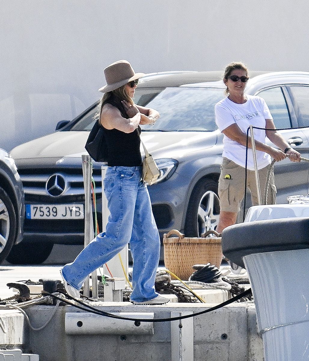 Jennifer Aniston was spotted in Palma de Mallorca during her trip for the Fourth of July weekend, wearing a black tank top, loose jeans, a wide-brimmed hat, and comfortable sneakers.