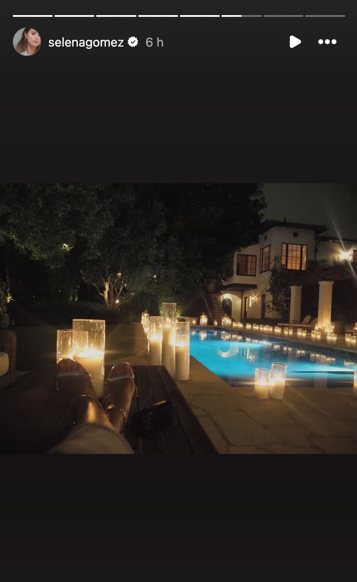 Candles lit up the night sky around their pool, where Gomez posed in a ruched gray Louis Vuitton gown with her arms outstretched and the biggest smile.