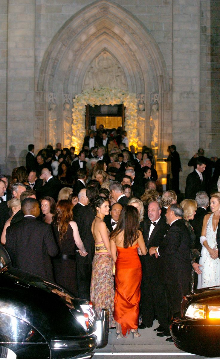 Wedding guests, including Billy Joel (lower right) and wife Kate Lee Joel (in pink and yellow dress), leave the Episcopal Church of Bethesda-by-the-Sea in Palm Beach, Fla., after the wedding of billionaire Donald Trump and Slovenian model Melania Knauss.  