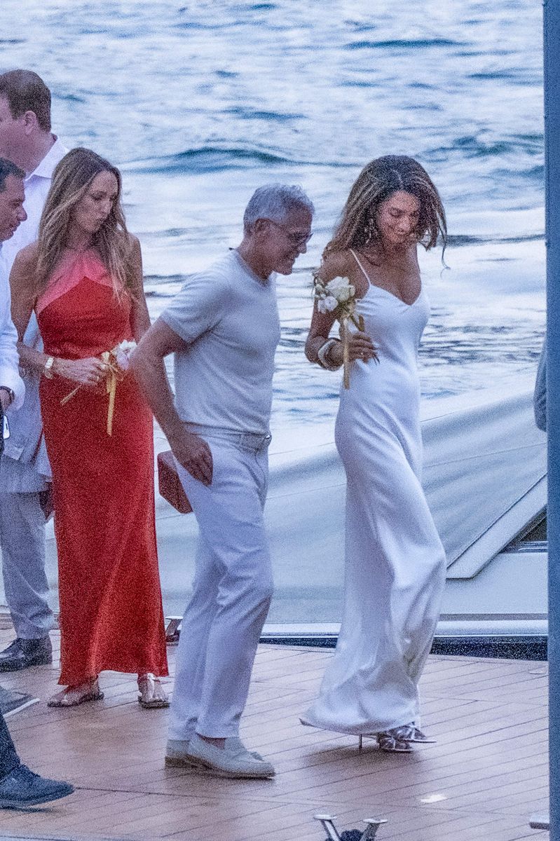 The human rights lawyer paired her floor-length white dress with metallic silver heels and a sparkling floral handbag.