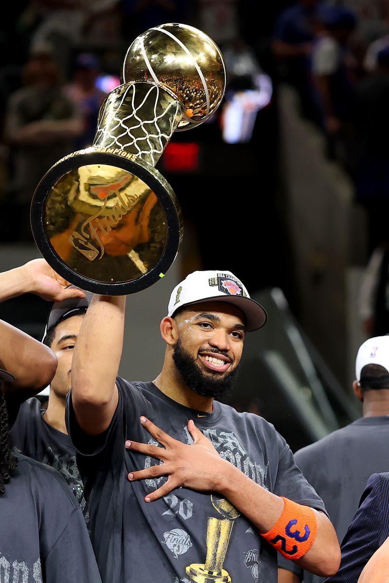 Karl-Anthony Towns #32 celebrates with the Larry O'Brien Championship Trophy after the victory against the San Antonio Spurs in Game Five of the 2026 NBA Finals.