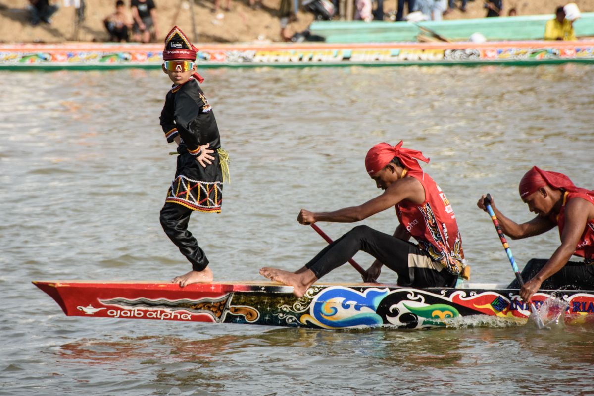 Rayyan Arkan Dikha (L), an 11-year-old boy who went viral for his calm dance on the bow of a traditional longboat