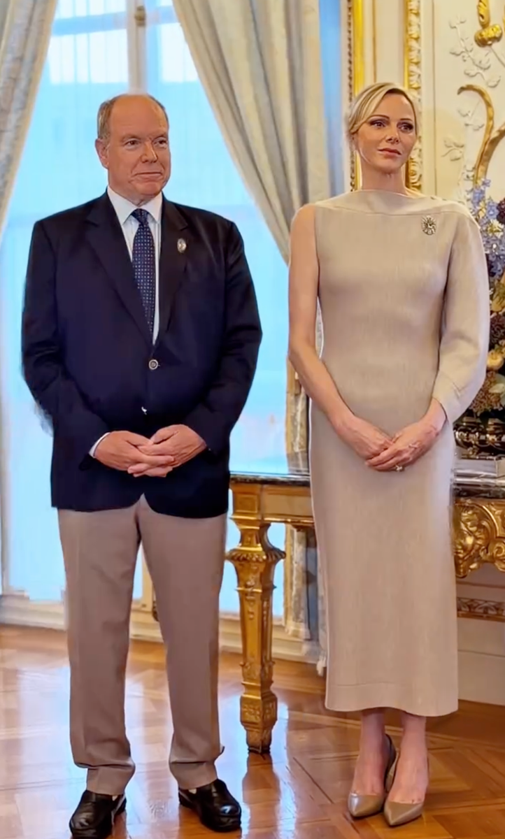 Princess Charlene embraced understated elegance in a sleek neutral dress featuring a striking asymmetrical one-sleeve design.