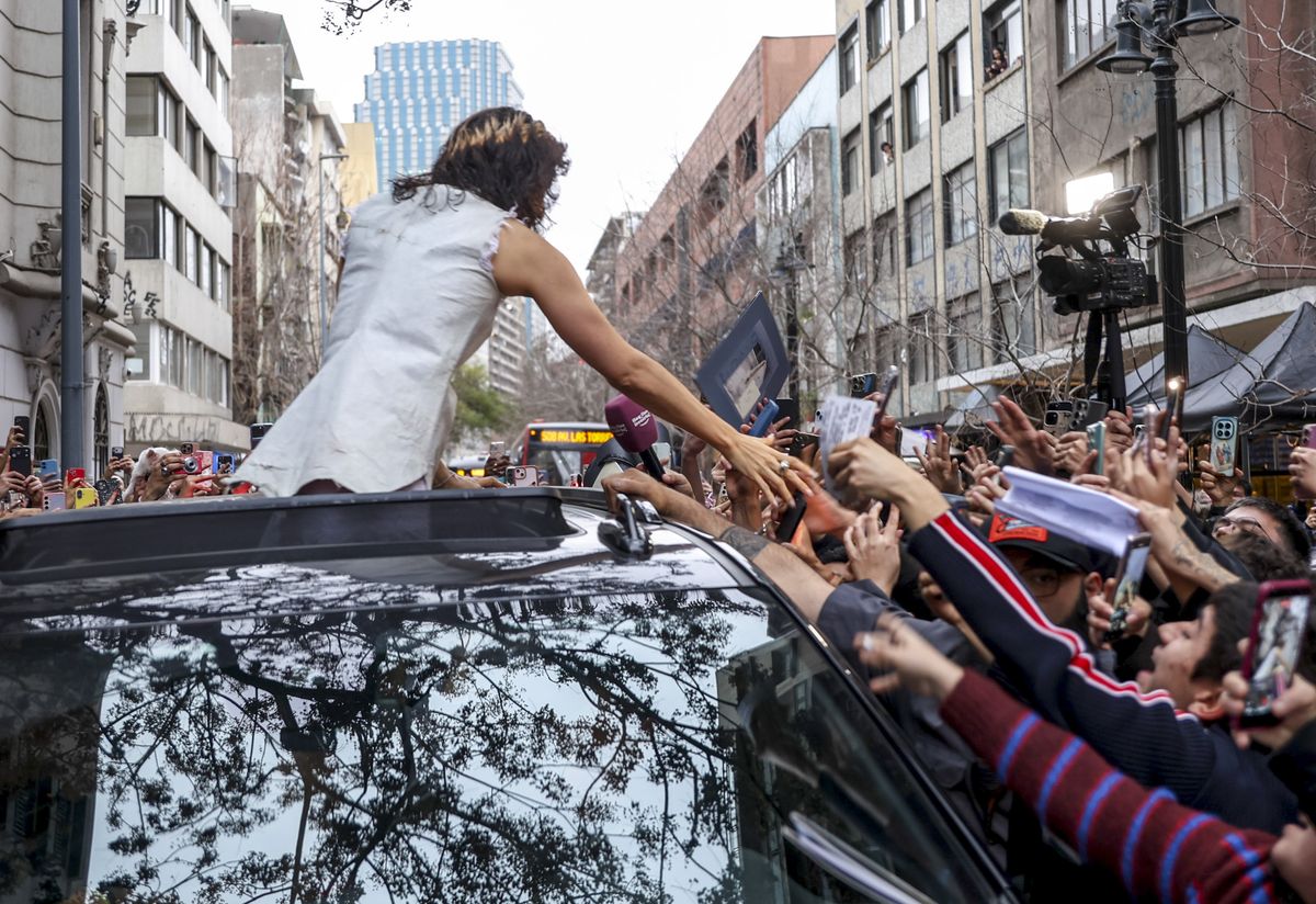 The Spanish superstar waves to hundreds of supporters who gathered to welcome her in the Chilean capital.