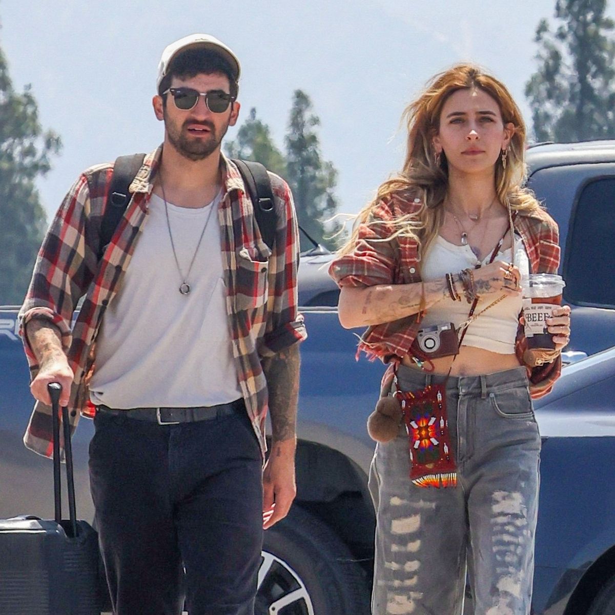 Paris Jackson and rumored new boyfriend Hayden Karchmer coordinated in matching plaid layers and earthy tones during the casual airport outing.