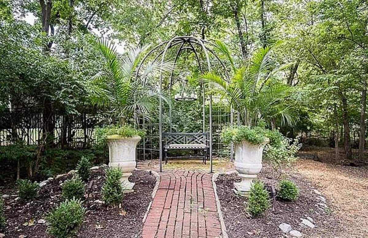 The backyard was fairly plain with a few scattered plants, wood chips, and a wrought iron gazebo.